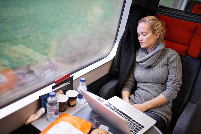 Picture of young professional women travelling on the train asleep with laptop open on the table